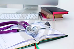 Stethoscope lying on a table on an open book