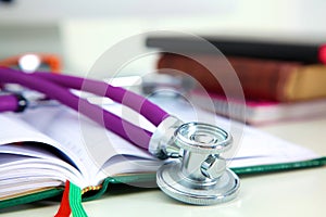 Stethoscope lying on a table on an open book