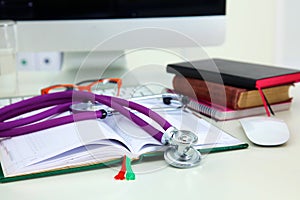 Stethoscope lying on a table on an open book