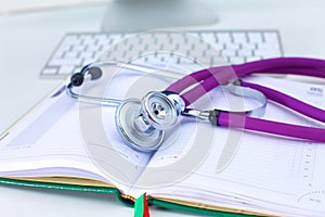 Stethoscope lying on a table an open book
