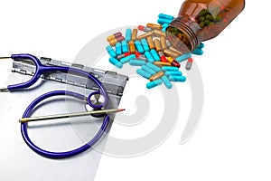 A stethoscope ,medical history folder clipboard and colorful tablets medicine in black bottle on white