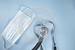 Stethoscope and medical mask on table