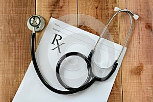 Stethoscope and medical prescription on wooden background.