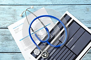 Stethoscope with medical record on wooden background. Health care concept