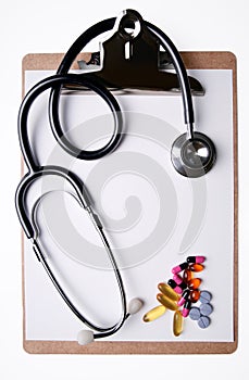 Stethoscope and medicine on clipboard photo