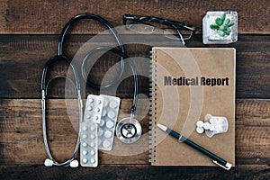 Stethoscope, medicine drug and notebook wtih MEDICAL REPORT word on its cover