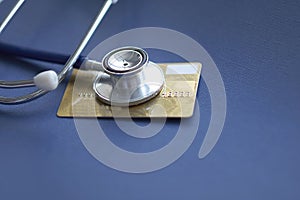 Stethoscope on Mock up Credit Card with number on cardholder in hospital desk. Health insurance and cost of care, self