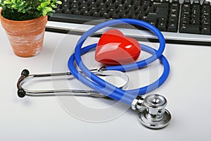 Stethoscope on modern laptop computer. red heart on white table with space for text. Healthcare concept