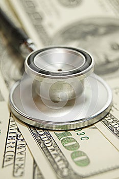 Stethoscope on money background and pills