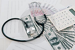 stethoscope money and calculator on table in clinic health