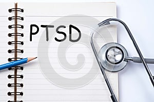 Stethoscope on notebook and pencil with PTSD - post traumatic st photo