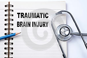 Stethoscope on notebook and pencil with Traumatic Brain Injury