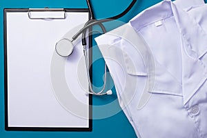 Stethoscope, notepad, folded doctor`s uniform lie on the table