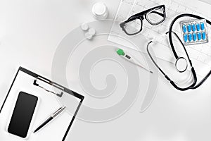 Stethoscope in the office of doctors.Top view of doctor`s desk table, blank paper on clipboard with pen. Copy space