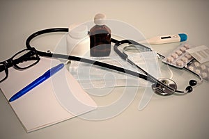 Stethoscope in the office of doctors.Top view of doctor`s desk table, blank paper on clipboard with pen. Copy space