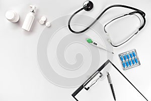 Stethoscope in the office of doctors.Top view of doctor`s desk table, blank paper on clipboard with pen. Copy space