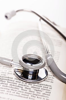 Stethoscope on old book on white background