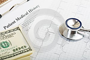 Stethoscope over ecg graph and 100 dollar