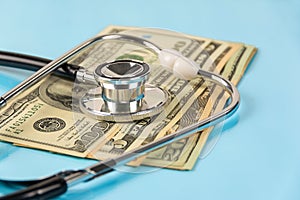 Stethoscope over money dollar on Blue background