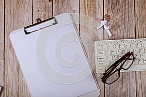 Stethoscope and paper notebook on keyboard on a wooden table background