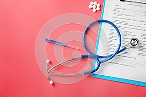 Stethoscope with patient medical history and syringe on color background. Health care concept