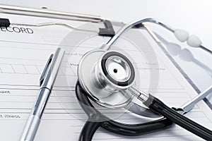 Stethoscope and pen on medical record.