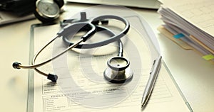 Stethoscope and pen on medical records in doctor premise