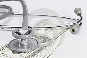 Stethoscope on a pile of money.