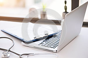 Stethoscope, pills, laptop on white background. Medicine concept