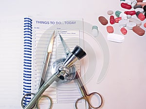 Stethoscope,planner,instruments and medines on the table.