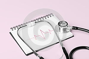 Stethoscope and Pulse Heartbeat Notebook Still Life Object on Pink Background