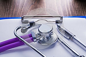 Stethoscope with purple tubes and ballpoint pen on