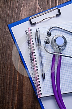 Stethoscope with purple tubes on clipboard