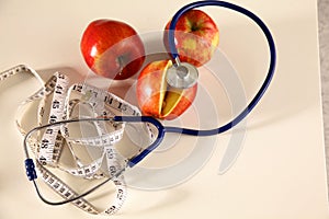Stethoscope with red apples on a white background