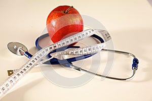 Stethoscope with red apples on a white background