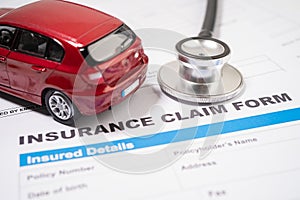 Stethoscope with red car on Insurance  claim accident car form, Car loan, insurance and leasing time concepts