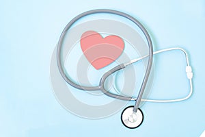 Stethoscope and red heart shape on blue background, Heart and health care concept