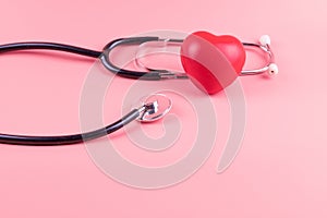 Stethoscope with Red heart shape on pink background. Healthcare, life Insurance, World Heart Day amd cancer concept