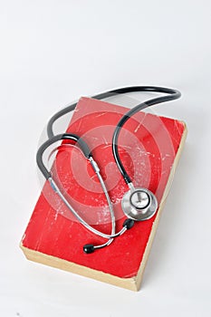 Stethoscope on red old book