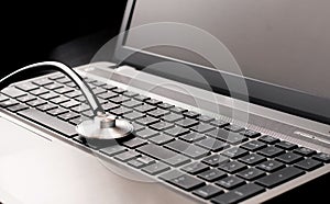 Stethoscope resting on a computer keyboard -