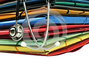 Stethoscope resting on a pile of folders photo