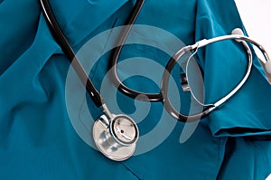 Stethoscope and scrubs on white background