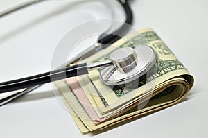 Stethoscope sitting on US dollar bills