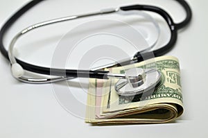 Stethoscope sitting on US dollar bills