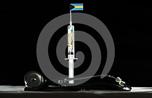 Stethoscope and syringe filled with drugs injecting the Bahamian