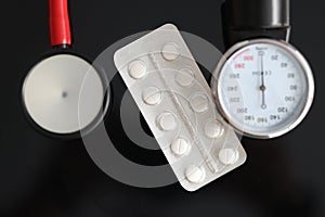 Stethoscope of tablet on table. Medicines to normalize high blood pressur