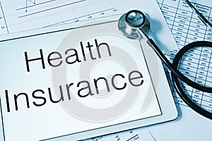 Stethoscope and text health insurance in the screen of a tablet