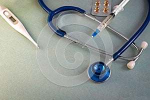 Stethoscope textured background, pills, thermometer, syringe