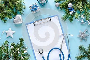 Stethoscope, thermometer, blank clipboard and Christmas decorations. Medical concept. New Year`s and Christmas. Top view