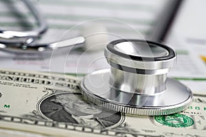 Stethoscope and US dollar banknotes on chart or graph paper
